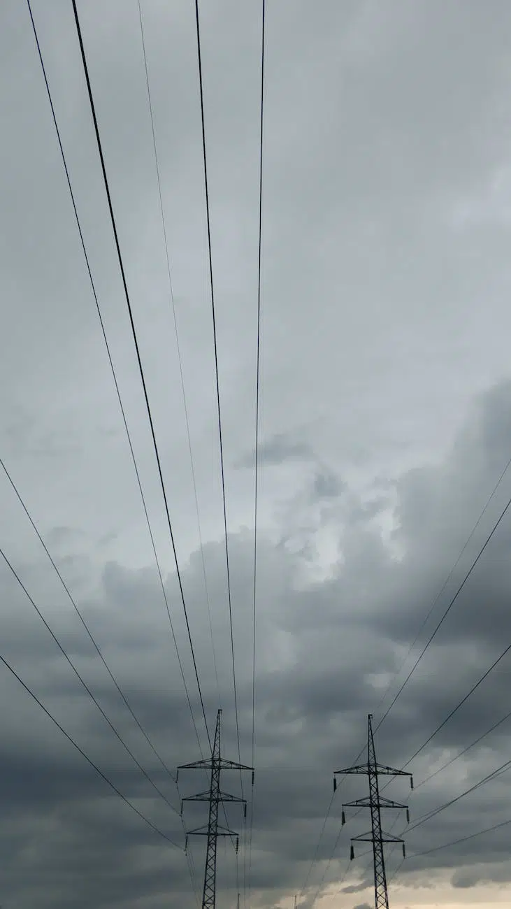 overhead power line on cloudy sky at dusk